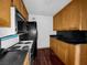 Kitchen featuring wood cabinets and black appliances with view to the adjacent wall at 540 Tam O Shanter, Las Vegas, NV 89109