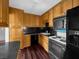 Functional kitchen with wood cabinets and black appliances including oven, microwave, and refrigerator at 540 Tam O Shanter, Las Vegas, NV 89109