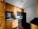 Functional kitchen with wood cabinets and black appliances including oven, microwave, and refrigerator at 540 Tam O Shanter, Las Vegas, NV 89109
