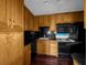 Functional kitchen with wood cabinets and black appliances including oven, microwave, and refrigerator at 540 Tam O Shanter, Las Vegas, NV 89109