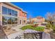 Inviting backyard with lush turf, lounge chairs, hot tub, and stylish landscaping under a clear blue sky at 5626 Deer Creek Falls Ct, Las Vegas, NV 89118