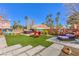 Backyard with artificial turf, concrete pavers, muraled walls, palm trees, and a hot tub at 5626 Deer Creek Falls Ct, Las Vegas, NV 89118