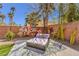 A backyard lounge area with a muraled wall, a daybed, and palm trees at 5626 Deer Creek Falls Ct, Las Vegas, NV 89118