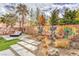 Stylized backyard featuring an outdoor lounge area, playful wall murals, desert landscaping, and a stone pathway at 5626 Deer Creek Falls Ct, Las Vegas, NV 89118