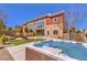 Landscaped backyard featuring a turf lawn, lounge chairs, mural wall and a relaxing hot tub at 5626 Deer Creek Falls Ct, Las Vegas, NV 89118