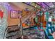 Eclectic game room featuring a pinball machine, graphic stairs, and loft with cool art, perfect for recreation at 5626 Deer Creek Falls Ct, Las Vegas, NV 89118