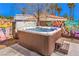 Inviting backyard hot tub with wood finish, graffiti background wall, and convenient steps at 5626 Deer Creek Falls Ct, Las Vegas, NV 89118