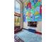 Spacious living room with large mural, modern furniture, and ample natural light from the expansive windows at 5626 Deer Creek Falls Ct, Las Vegas, NV 89118