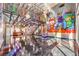 Open floorplan living room featuring vibrant graffiti art, high ceilings, and unique design elements at 5626 Deer Creek Falls Ct, Las Vegas, NV 89118