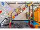 Fun staircase with colorful murals, pinball machine, epoxy floors, and metal railings at 5626 Deer Creek Falls Ct, Las Vegas, NV 89118