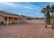 Private backyard with stone landscaping, covered patio, and tall privacy fence at 6436 Point Break St, North Las Vegas, NV 89084