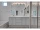 Clean bathroom with dual vanities, tile flooring and a large mirror at 6436 Point Break St, North Las Vegas, NV 89084