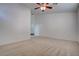 Spacious bedroom with neutral carpet, a ceiling fan, and an ensuite bathroom at 6436 Point Break St, North Las Vegas, NV 89084
