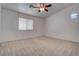 Neutral bedroom with a ceiling fan, carpeted floors, and a window allowing for natural light at 6436 Point Break St, North Las Vegas, NV 89084