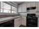Kitchen boasts black appliances, white cabinets, and a granite countertop at 6436 Point Break St, North Las Vegas, NV 89084