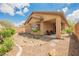Serene backyard with a covered patio and meticulously landscaped desert surroundings, complemented by lush greenery at 6737 Divers Loons St, North Las Vegas, NV 89084