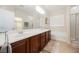Bright bathroom with double sinks, a soaking tub, and a separate shower for modern convenience at 6737 Divers Loons St, North Las Vegas, NV 89084