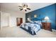 Spacious bedroom with a ceiling fan, blue accent wall, and plush carpeting at 6737 Divers Loons St, North Las Vegas, NV 89084