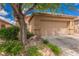 Front exterior view of home featuring desert landscaping, mature shade tree and two car garage at 6737 Divers Loons St, North Las Vegas, NV 89084