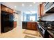 View of the kitchen, featuring dark wood cabinets, breakfast nook and stainless steel appliances at 6737 Divers Loons St, North Las Vegas, NV 89084