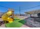 This backyard features an installed playground set, gravel and an expansive patio at 7 Church St, Henderson, NV 89015