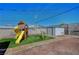 Fenced backyard featuring a playset, small storage shed, and gravel at 7 Church St, Henderson, NV 89015