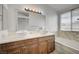 Bright bathroom featuring double sinks, stylish vanity, and a soaking tub near a window at 7888 Bonaventure Dr, Las Vegas, NV 89147