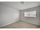 Cozy bedroom with wood-look floors, a window overlooking the neighborhood and neutral paint at 7888 Bonaventure Dr, Las Vegas, NV 89147