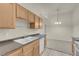Bright eat-in kitchen area featuring wood cabinetry, a dual basin sink, and modern appliances at 8805 Jeffreys St # 2020, Las Vegas, NV 89123