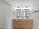 Modern bathroom with double vanity, wood cabinets, contemporary fixtures, and sliding door closet at 9115 Weeping Hollow Ave, Las Vegas, NV 89178