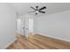Bedroom with wood-look floors, neutral walls, a ceiling fan, and a door at 9115 Weeping Hollow Ave, Las Vegas, NV 89178