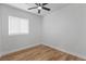 Bright bedroom with wood-look floors, neutral walls, a ceiling fan, and a window with blinds at 9115 Weeping Hollow Ave, Las Vegas, NV 89178