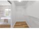 A modern closet featuring shelving and wood floors adjacent to a stand alone tub bathroom at 9115 Weeping Hollow Ave, Las Vegas, NV 89178