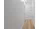 Clean hallway with wood-look flooring and minimalist shelving at 9115 Weeping Hollow Ave, Las Vegas, NV 89178
