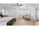 A bright main bedroom featuring wood floors, a ceiling fan, and lots of natural light at 9115 Weeping Hollow Ave, Las Vegas, NV 89178