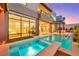 Luxurious outdoor pool area with a hot tub, covered patio, and access to the home's interior at 10718 Desert Heights Ave, Las Vegas, NV 89135