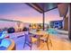 Cozy outdoor seating area with a dining table, ambient lighting, and a view of the pool and spa at 10718 Desert Heights Ave, Las Vegas, NV 89135