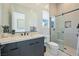 Modern bathroom with a large mirror, sleek vanity, and a glass-enclosed shower with recessed shelving at 10718 Desert Heights Ave, Las Vegas, NV 89135