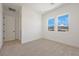 Bright bedroom featuring neutral carpet, white walls, and two windows with mountain views at 10718 Desert Heights Ave, Las Vegas, NV 89135