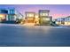 Modern two-story home featuring sleek lines, a two-car garage, and manicured landscaping at dusk at 10718 Desert Heights Ave, Las Vegas, NV 89135
