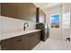 Well-equipped laundry room with ample storage, modern appliances, and a bright window at 10718 Desert Heights Ave, Las Vegas, NV 89135