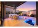 Outdoor dining area with a modern fire pit and a built-in kitchen under a covered patio at 10718 Desert Heights Ave, Las Vegas, NV 89135