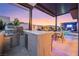 Outdoor kitchen with marble countertops, stainless steel grill, and dining area by the pool at 10718 Desert Heights Ave, Las Vegas, NV 89135