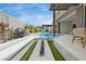 Modern home showcasing a luxurious outdoor living space with a sleek pool and marble lined firepit with seating at 10718 Desert Heights Ave, Las Vegas, NV 89135