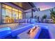 Outdoor dining area with a fire pit, bar seating, and view of the home's interior at 10718 Desert Heights Ave, Las Vegas, NV 89135