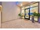 Inviting covered patio with brick pavers, potted plants, and a glimpse of the interior through glass doors at 10718 Desert Heights Ave, Las Vegas, NV 89135