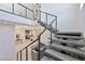 Modern staircase with sleek railing leads to a bright, open-concept living space at 10718 Desert Heights Ave, Las Vegas, NV 89135