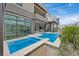 Contemporary home showcasing a luxurious swimming pool with a connecting water feature and outdoor living space at 10718 Desert Heights Ave, Las Vegas, NV 89135