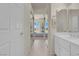 Bright bathroom featuring a double sink vanity and a view into the main bedroom at 11032 Mission Lakes Ave, Las Vegas, NV 89134