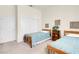 A naturally illuminated bedroom featuring two beds, a bookshelf, and a closet at 11032 Mission Lakes Ave, Las Vegas, NV 89134